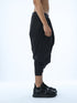 Detail of black wide pleated men’s capri pants by Junus Coban