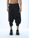 Junus Coban men’s wide pleated drop-crotch capri pants in black front view