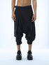 Junus Coban men’s wide pleated drop-crotch capri pants in black front view