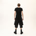 Back view of men’s black asymmetric raw seam T-shirt with bold Junus Coban streetwear styling.