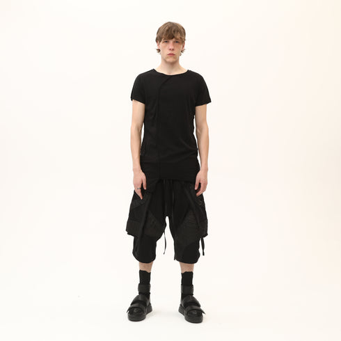 Front view of men’s black asymmetric raw seam T-shirt with uneven hem and avant-garde streetwear styling.