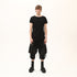 Front view of men’s black asymmetric raw seam T-shirt with uneven hem and avant-garde streetwear styling.