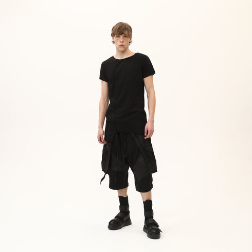 Full styling view of men’s black asymmetric raw seam T-shirt for festival and streetwear outfits.