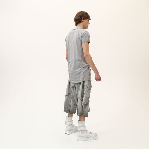 Back angle view of men’s grey asymmetric raw seam T-shirt with layered raw seam detail.