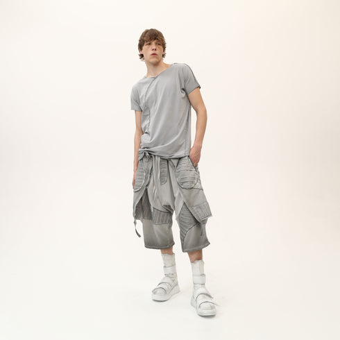 Full styling view of men’s grey asymmetric raw seam T-shirt for avant-garde festival outfits.