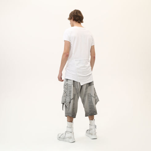 Back angle view of men’s white asymmetric raw seam T-shirt with raw edge construction.