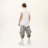 Back angle view of men’s white asymmetric raw seam T-shirt with raw edge construction.