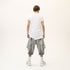 Back view of men’s white asymmetric raw seam T-shirt with irregular hem and Junus Coban attitude.