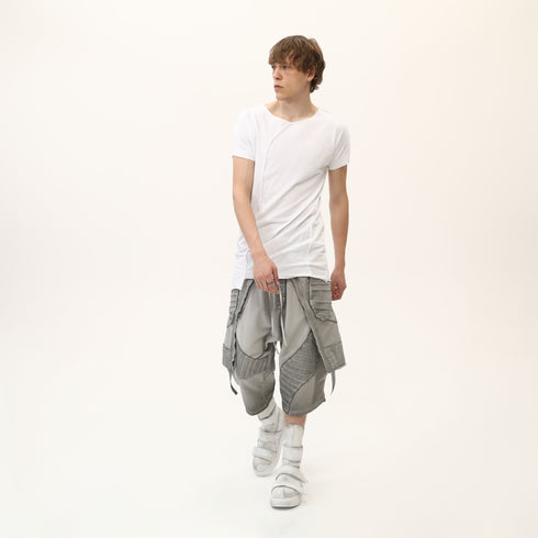 Full styling view of men’s white asymmetric raw seam T-shirt for festival and streetwear looks.