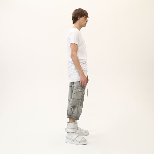 Side profile of men’s white asymmetric raw seam T-shirt with short sleeves and regular fit.