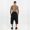 Back view of men’s black paneled drop-crotch capri pants with cropped length and bold streetwear silhouette.