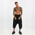 Full look of men’s black drop-crotch capri pants with front and back paneled detailing and bold festival-ready attitude.