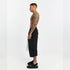 Side view of men’s black capri pants with front and back paneled construction, drop-crotch fit and side pocket detail.