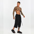 Styling view of men’s black paneled capri pants worn with sandals for an avant-garde summer streetwear look.