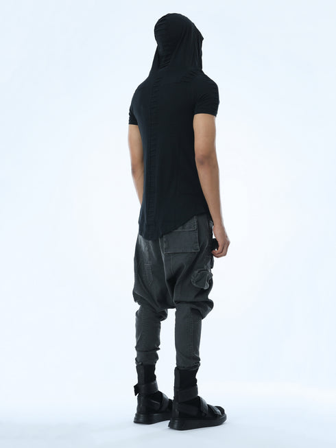 Back angle view of men’s black hooded T-shirt showing pleated hood and back seam detail.