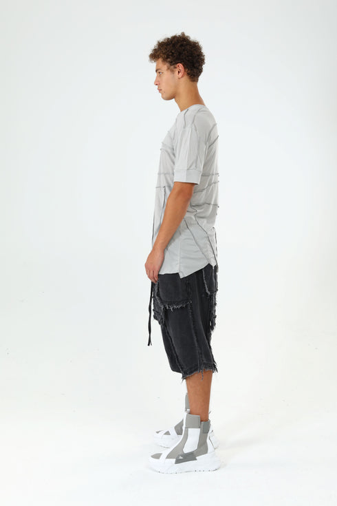 Side view of men’s grey paneled raw seam T-shirt with short sleeves and avant-garde streetwear styling.