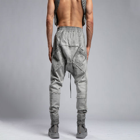 Back view of men’s anthracite piped raw stitch shalwar pants with avant-garde drop-crotch construction.