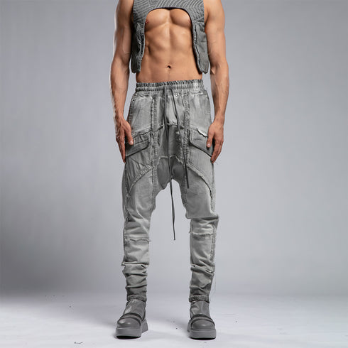 Close front view of men’s anthracite shalwar pants showing raw stitch details, piped trims and drawstring waist.