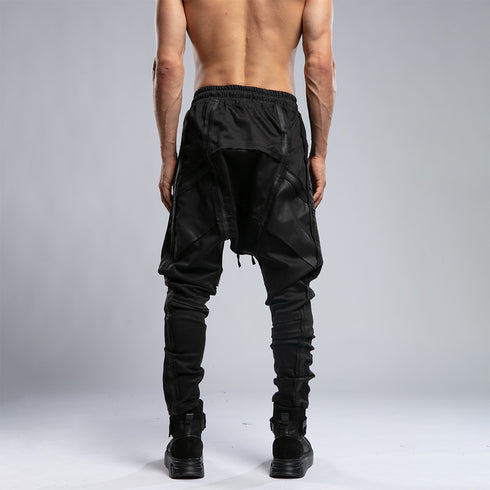 Back view of men’s black piped raw stitch shalwar pants with relaxed drop-crotch construction.