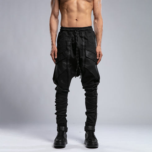 Close front view of men’s black shalwar pants showing piped trim, raw stitch details and adjustable drawstring waist.