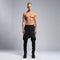 Front view of men’s black piped raw stitch shalwar pants with drop-crotch silhouette and elastic waistband.