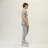 Side styling view of men’s anthracite raw seam T-shirt worn with light drop-crotch pants.