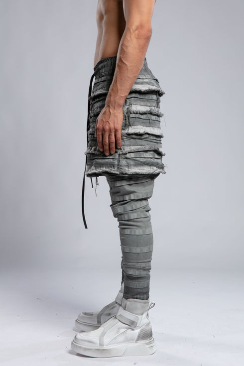 Junus Coban Men's Ribbed Raw Seam Pants in Grey three-quarter front view with sculptural layered texture
